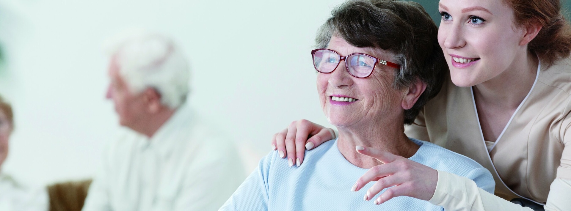 Pflegekraft kümmert sich um Seniorin